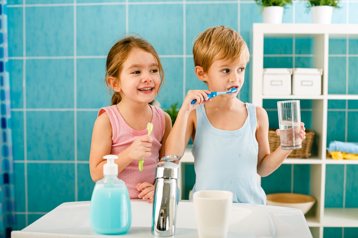 enfants en train de se brosser les dents dans la salle de bain hygiène dentaire brosse à dents dentifrice